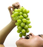 Woman Eating Grapes stock photo