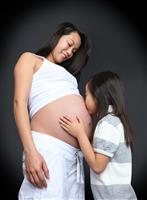 Girl Kissing Baby Pregnancy stock photo