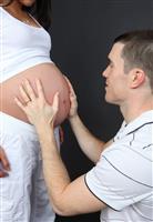Father Holding Baby in Pregnant Mom stock photo