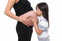 Girl Kissing Baby Pregnancy stock photo
