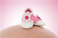 Baby Shoes on Pregnant Woman stock photo