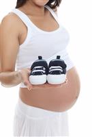 Pregnant Woman Holding Baby Shoes stock photo