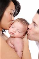 Parents Kissing Baby stock photo