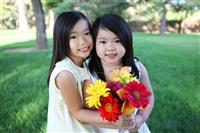 Cute Sisters with Flowers stock photo