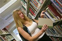 Young woman in library stock photo
