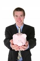 Business Man with Money (Focus on Piggy Bank) stock photo