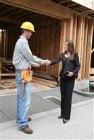 Woman Shaking Hands with Construction Man stock photo