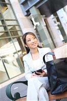 Asian Business Woman on Bench Outside Office stock photo