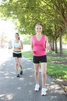 Pretty Sisters Jogging in Park stock photo