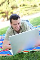 Young Man on Laptop in Park stock photo