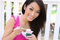 Pretty Asian Woman Eating Yogurt stock photo