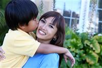Young Boy Kissing Mother stock photo
