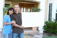 Happy Couple at Home with Sign stock photo