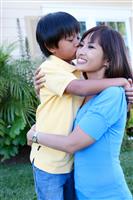 Young Boy Kissing Mother stock photo