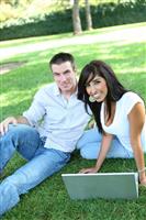 Attractive Couple in Park with Laptop stock photo