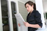 Woman at Home Reading Newspaper stock photo